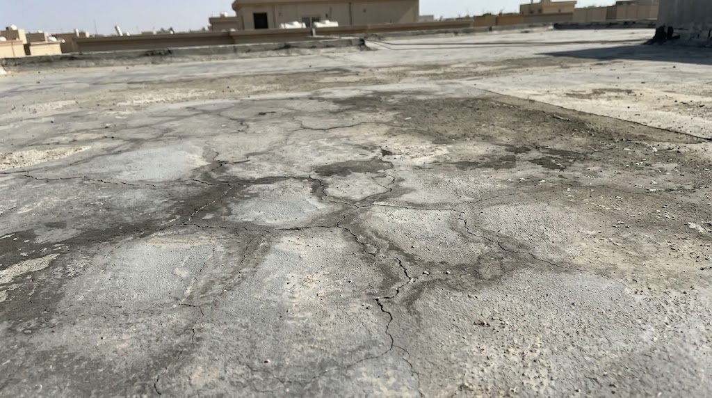 شقوق حرارية شعرية على سطح خرساني مكشوف في الرياض نتيجة الإجهاد الحراري المتكرر — عزل اسطح بالرياض يمنع هذا التلف